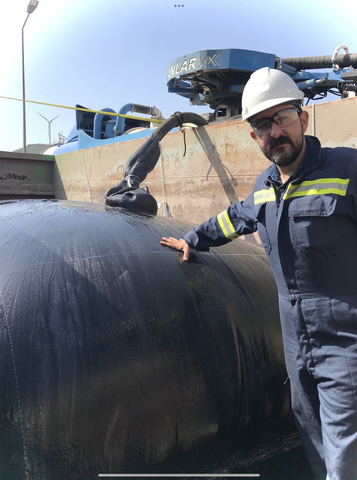Dolum yapılan geotekstil tüpün yanında saha ekibinden bir çalışan.